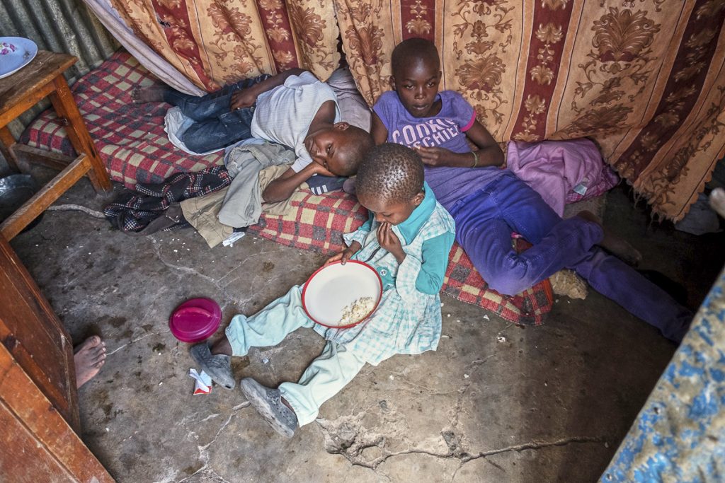 Pauline, 10, Benjamin 9 and Linet 5, are resting after the trip to visit their father who works as a watchman at the coal mine.